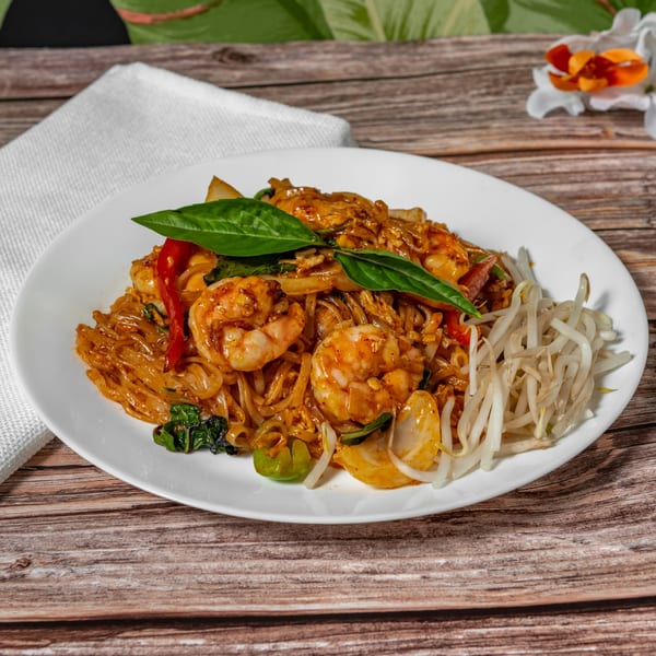 Sampannee Thai's Pad Kee Mao with shrimp, wide noodles, basil, and bean sprouts on a white plate.